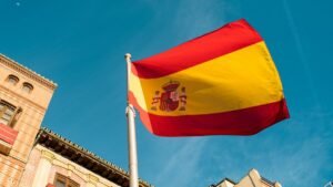 Spanish flag waving over city buildings – Spanish citizenship by residency 2026