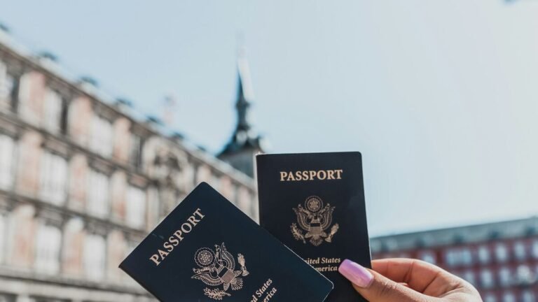 Two US passports held up in a Spanish city square – Spain digital nomad visa for Americans