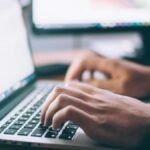 Person typing on a laptop while searching for jobs – Spain job seeker visa 2026