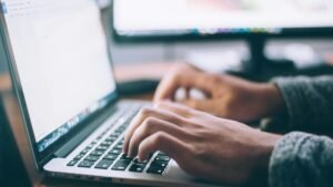 Person typing on a laptop while searching for jobs – Spain job seeker visa 2026